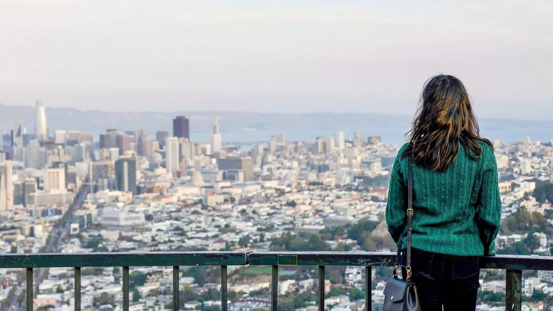 A woman looks at the 贝博体彩app skyline from 双峰.