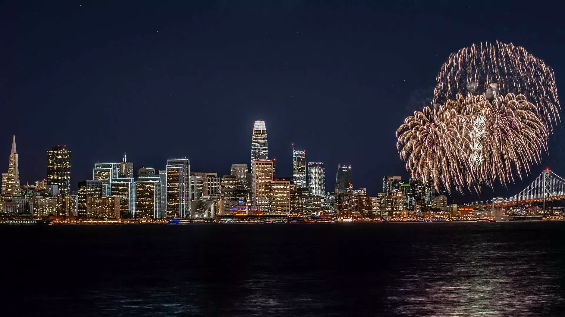 Des feux d'artifice explosent sur les toits de la ville de San Francisco.