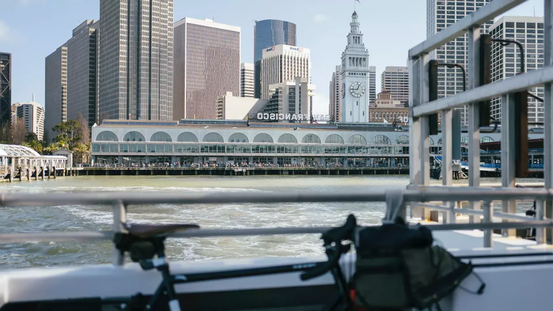 Bicicletta appoggiata a un binario con il Ferry Building sullo sfondo.