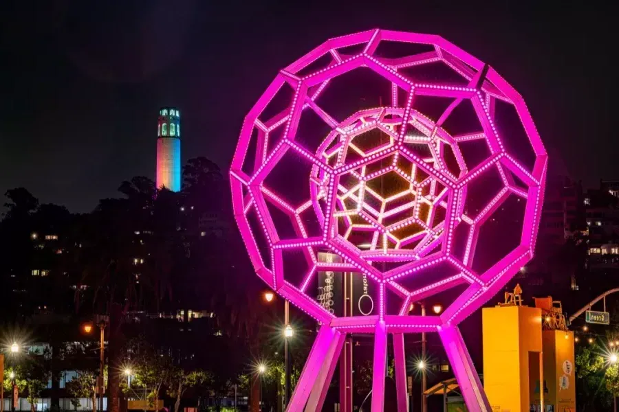 Buckyball leuchtet im Vordergrund, während Coit Tower in der Ferne leuchtet.