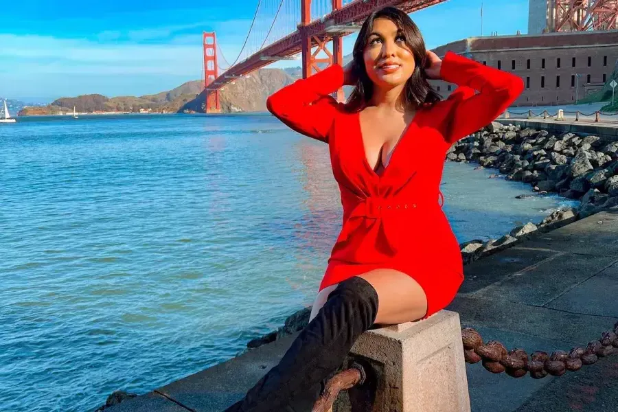 A stylish woman sits at Fort Point near the Golden Gate Bridge.